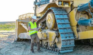 maintenance manager taking notes on an inspection of aggregate equipment