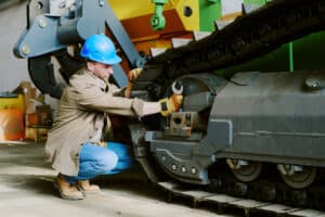 construction worker performing aggregate equipment maintenance